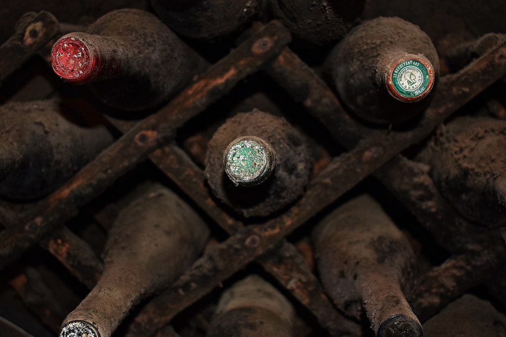 Botellero con viejos vinos, cubiertos de polvo